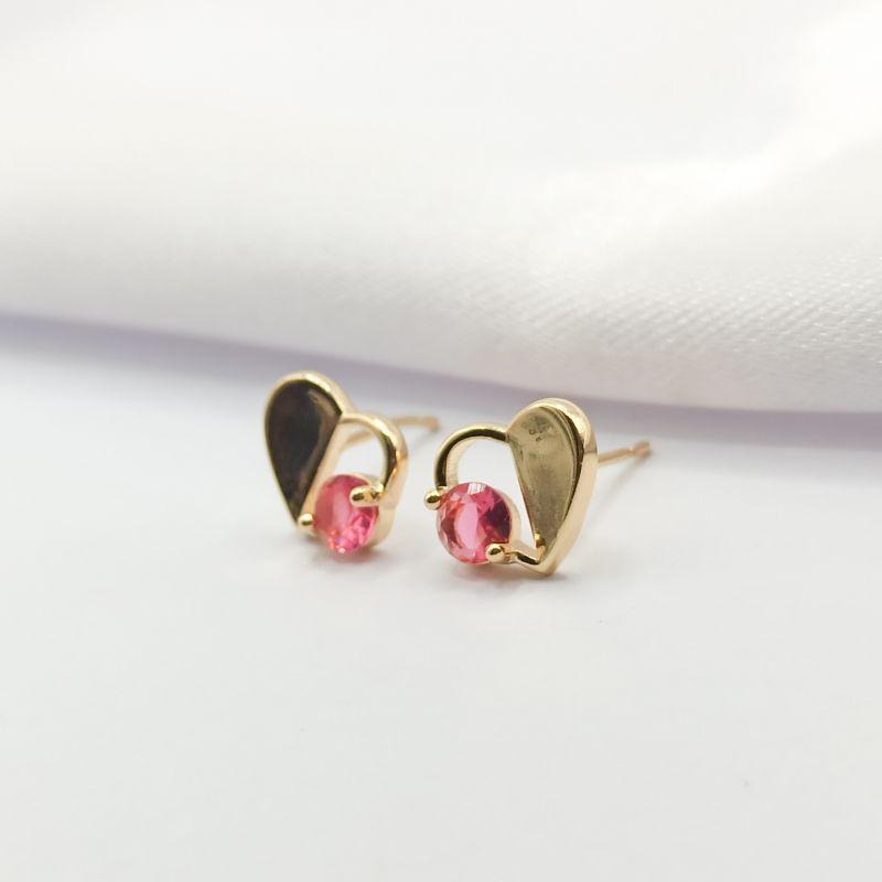 BRINCO DOURADO CORAÇÃO LADO VAZADO COM PONTO DE LUZ CRISTAL VERMELHO